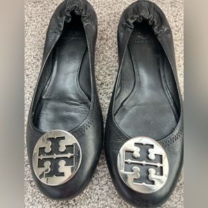 Tory Burch black flats with silver emblem.